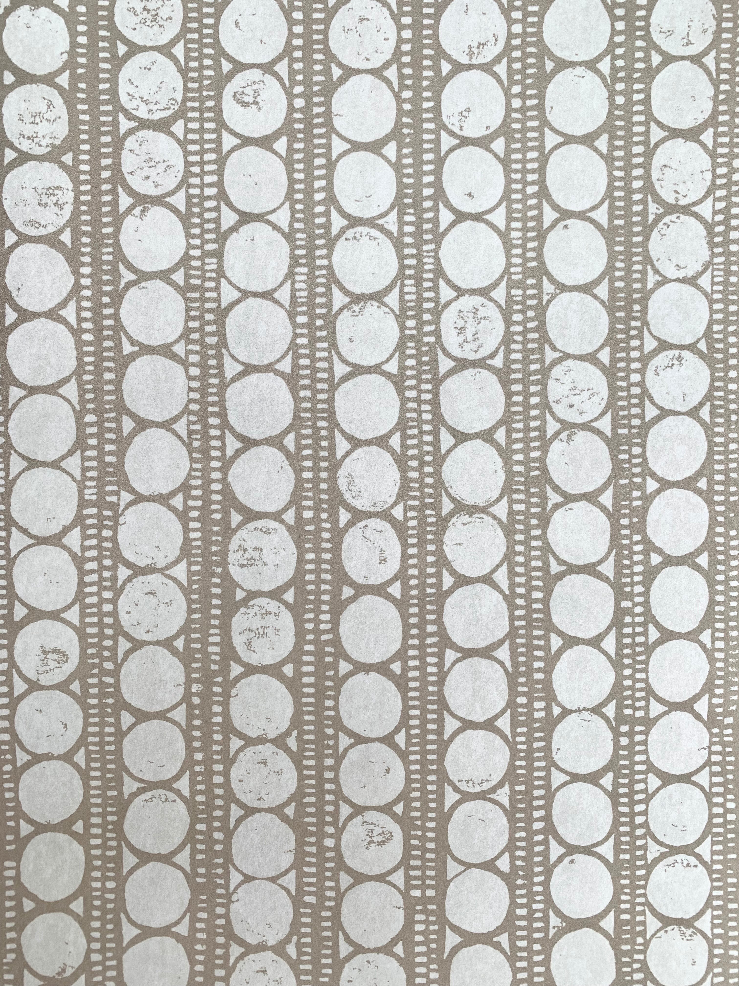 Detail of wallpaper in a circle and stripe print in white on a oatmeal field.