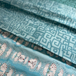 Stack of folded fabric swatches in various patterns in shades of blue