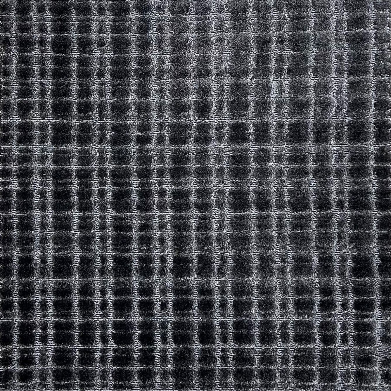 Broadloom carpet in a textural grid in charcoal grey. 
