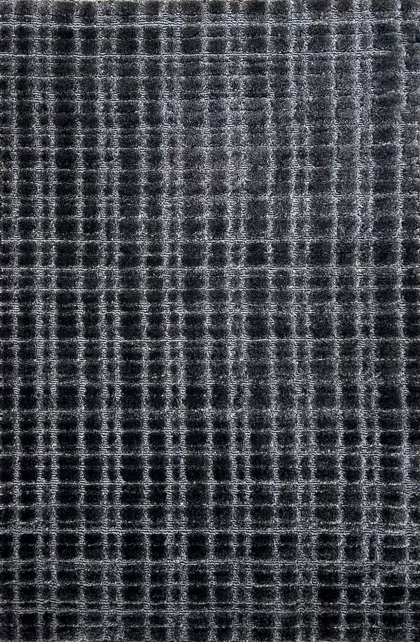 Broadloom carpet in a textural grid in charcoal grey. 
