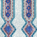 Detail of fabric in a geometric stripe pattern in shades of blue, orange and navy.