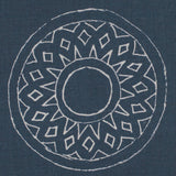 Detail of fabric in a repeating circular geometric print in light gray on a navy field.