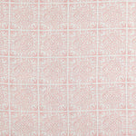 Detail of fabric in a damask lattice print in pink on a white field.