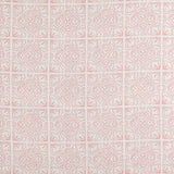 Detail of fabric in a damask lattice print in pink on a white field.