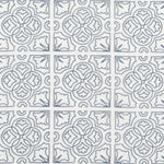 Detail of fabric in a damask lattice print in navy on a white field.