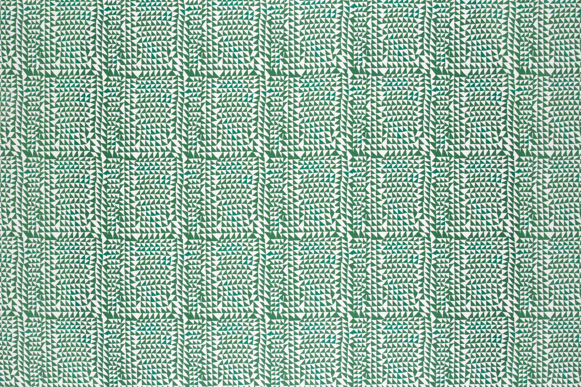 Detail of fabric in a dense triangle grid print in green on a white field.