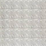 Detail of fabric in a dense triangle grid print in shades of brown on a white field.
