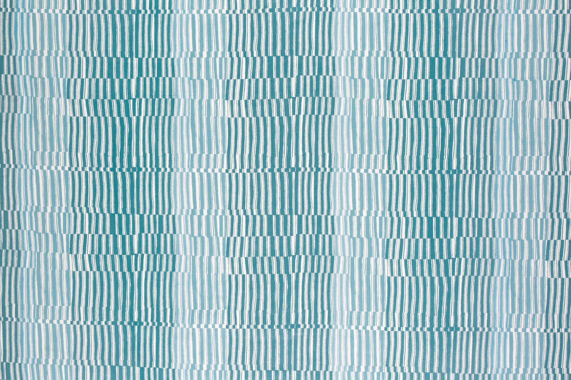 Detail of fabric in a dense broken stripe print in shades of blue and white.