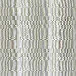 Detail of fabric in a dense broken stripe print in shades of tan, brown and white.