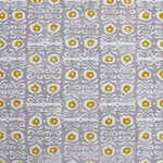 Fabric in a repeating damask print in white and gold on a light purple field.