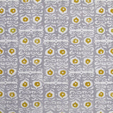 Fabric in a repeating damask print in white and gold on a light purple field.