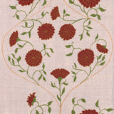 Detail of fabric in a floral lattice print in red, orange and green on a tan field.