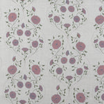 Detail of fabric in a floral lattice print in pink, purple and green on a tan field.