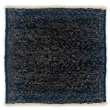Black textured rug with white border on a white background
