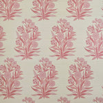 Detail of fabric in a repeating floral print in shades of pink and coral on a cream field.
