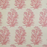 Detail of fabric in a repeating floral print in shades of pink and coral on a cream field.