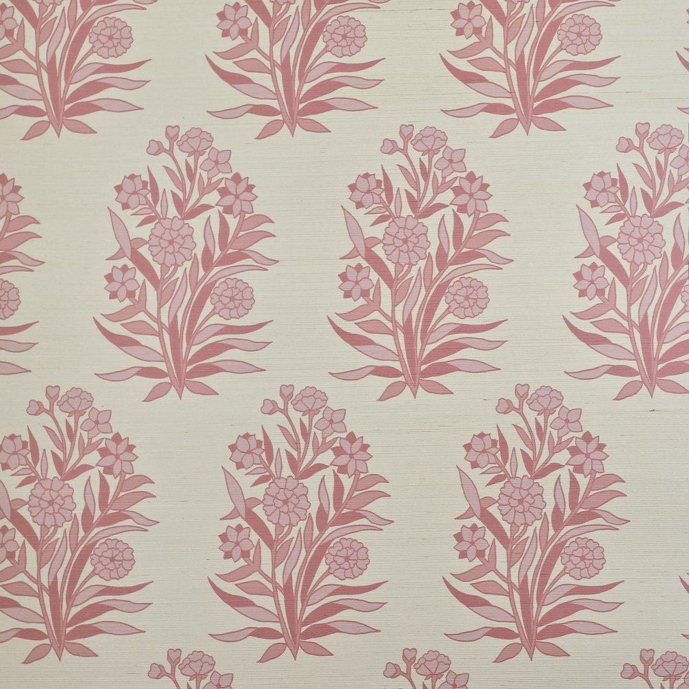 Detail of fabric in a repeating floral print in shades of pink and coral on a cream field.