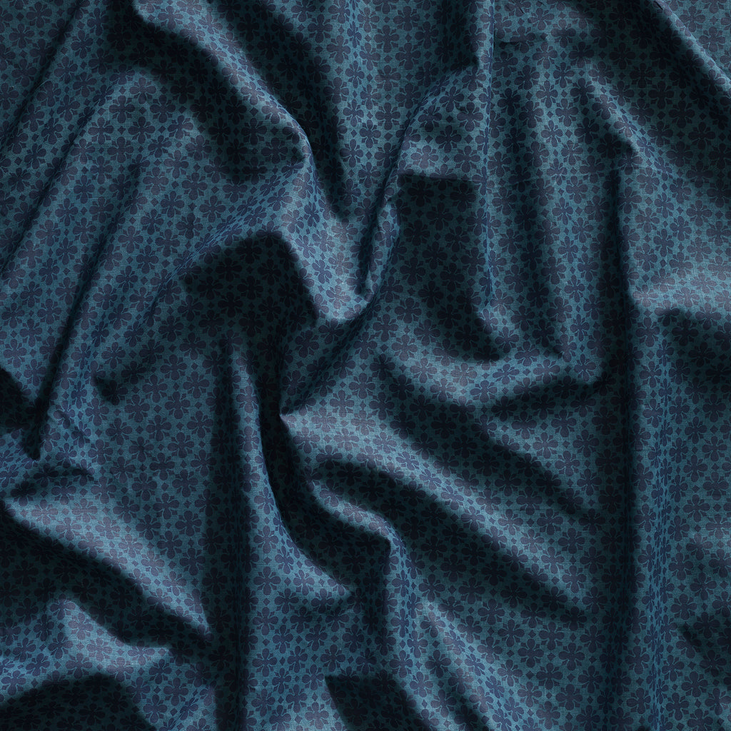 Close up of gently draped printed linen with dense floral medallion pattern in tonal dark blue.