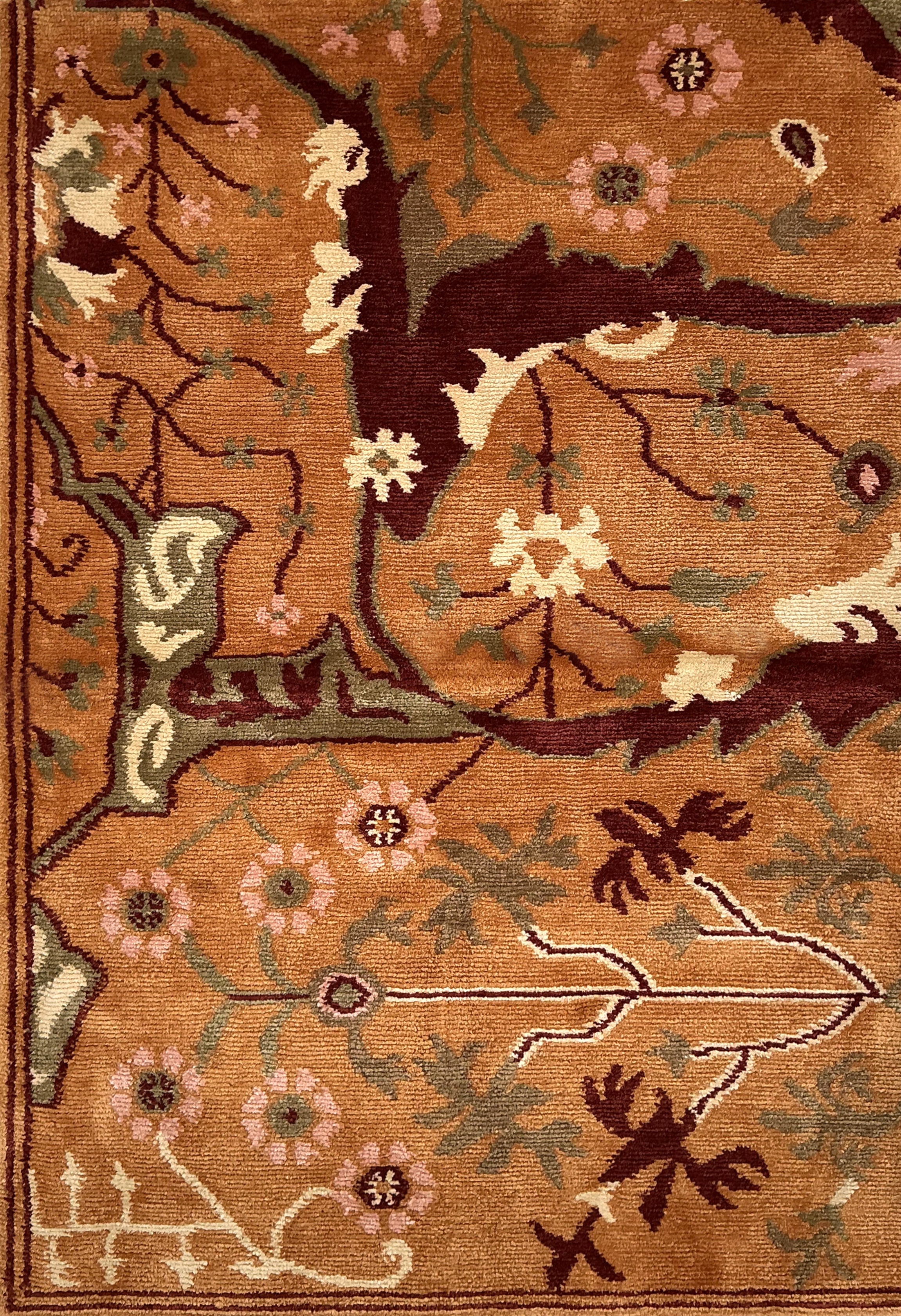 Close-up of a patterned rug with floral and leaf designs on a brown background