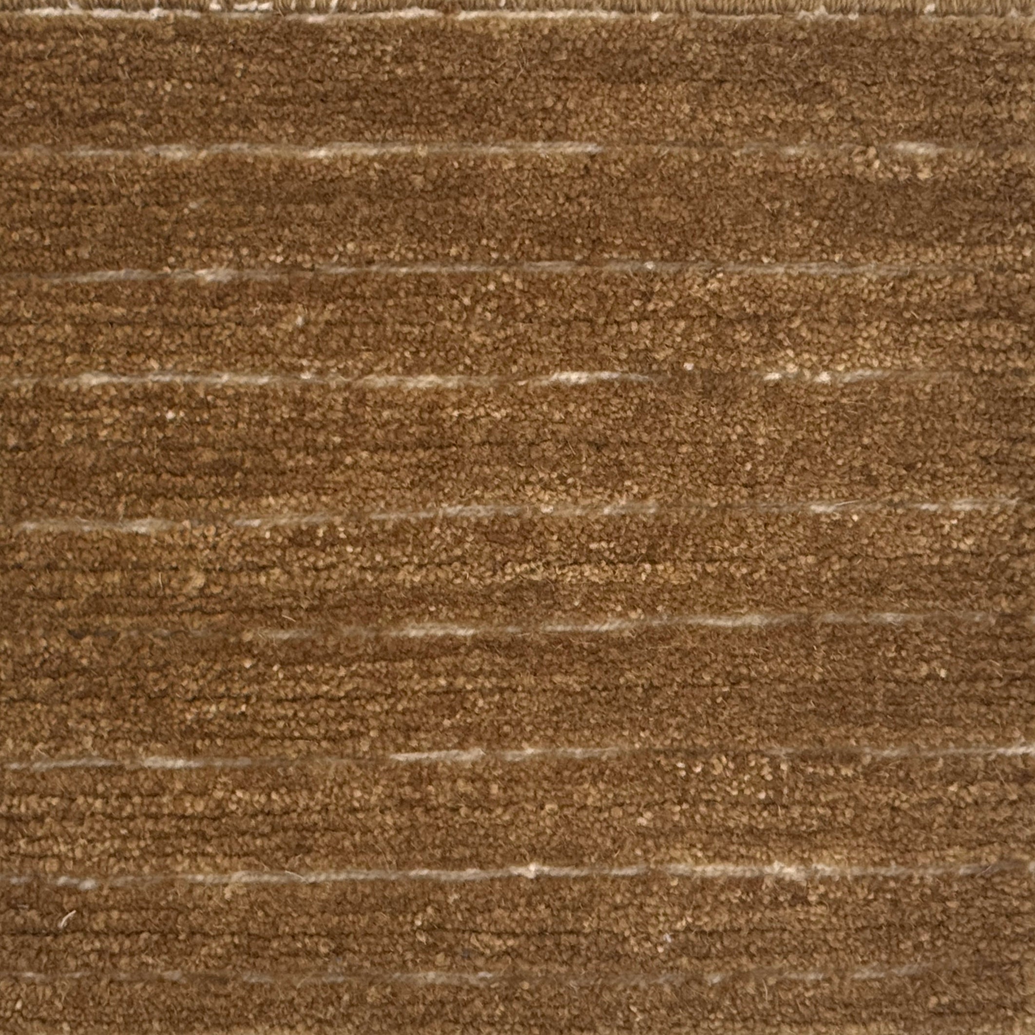 A close-up of a brown handknotted carpet with horizontal brushed lines 