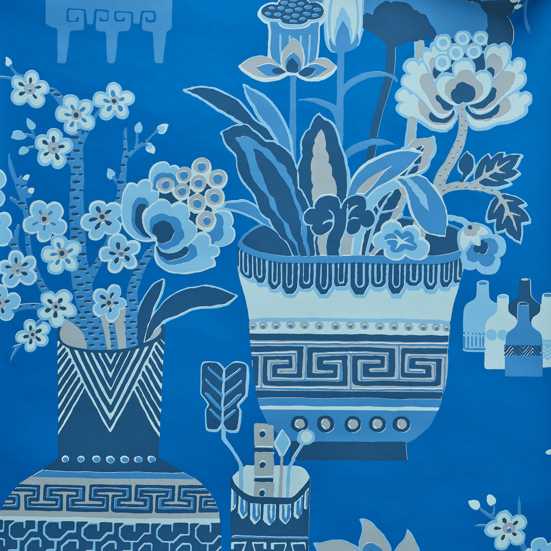 Close up of wallpaper in an ornate hand drawn urn and floral pattern in shades of  bright blue. 