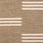 Broadloom flatweave carpet in a broken stripe in white on a brown field. 