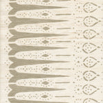 Detail of fabric in a bordered teardrop print in tan on a cream field.