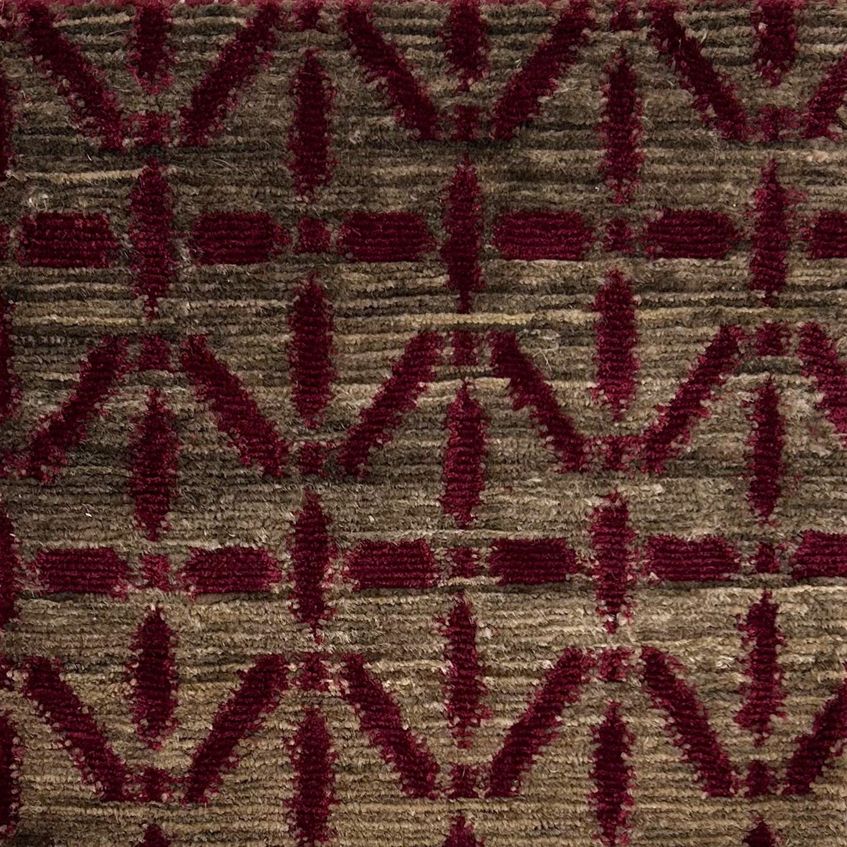 Handknotted rug with magenta linear design on a heather brown field. 