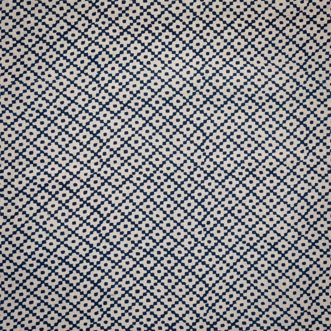 Detail of fabric in a diamond lattice print in navy on a cream field.