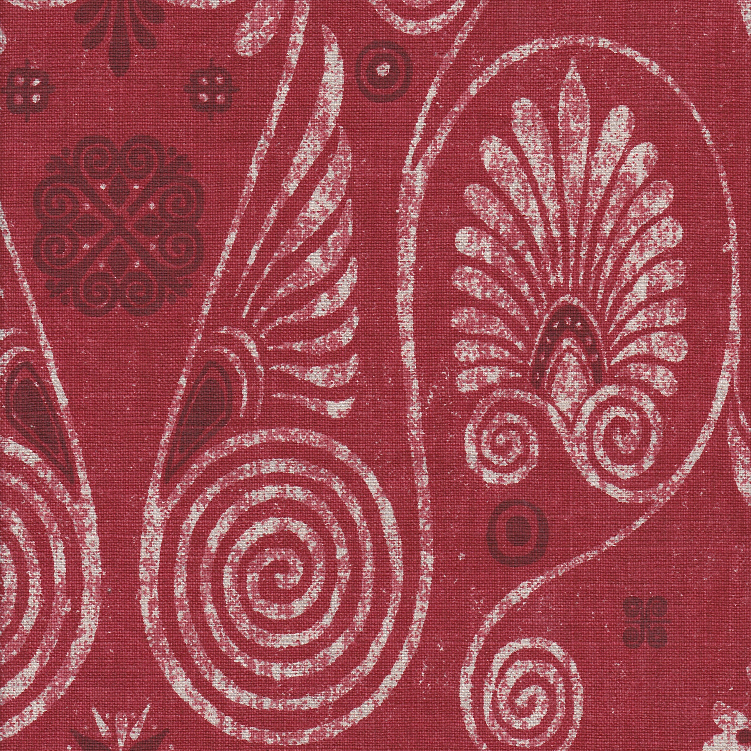 Detail of fabric in a damask print in shades of white and purple on a red field.