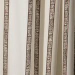 Draped printed fabric in a minimal geometric linear pattern in brown on a cream field.