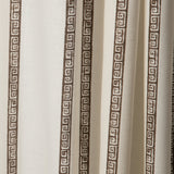 Draped printed fabric in a minimal geometric linear pattern in brown on a cream field.