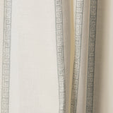 Draped printed fabric in a minimal geometric linear pattern in dusty blue on a cream field.