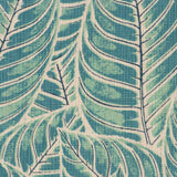Detail of fabric in a large-scale leaf print in shades of blue and turquoise on a tan field.