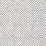 Detail of fabric in a geometric diamond print in gray on a cream field.