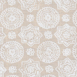 Detail of fabric in a geometric damask print in shades of cream on a tan field.