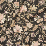 Close up of gently draped printed fabric in scrolling floral vine pattern in dark purple, blush pink, tan and brown on black.