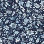 Close up of gently draped printed fabric in scrolling floral vine pattern in shades of blue and white on navy blue.