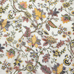 Close up of gently draped printed fabric in scrolling floral vine pattern in yellow, clay pink, orange, navy blue and olive green on white. 