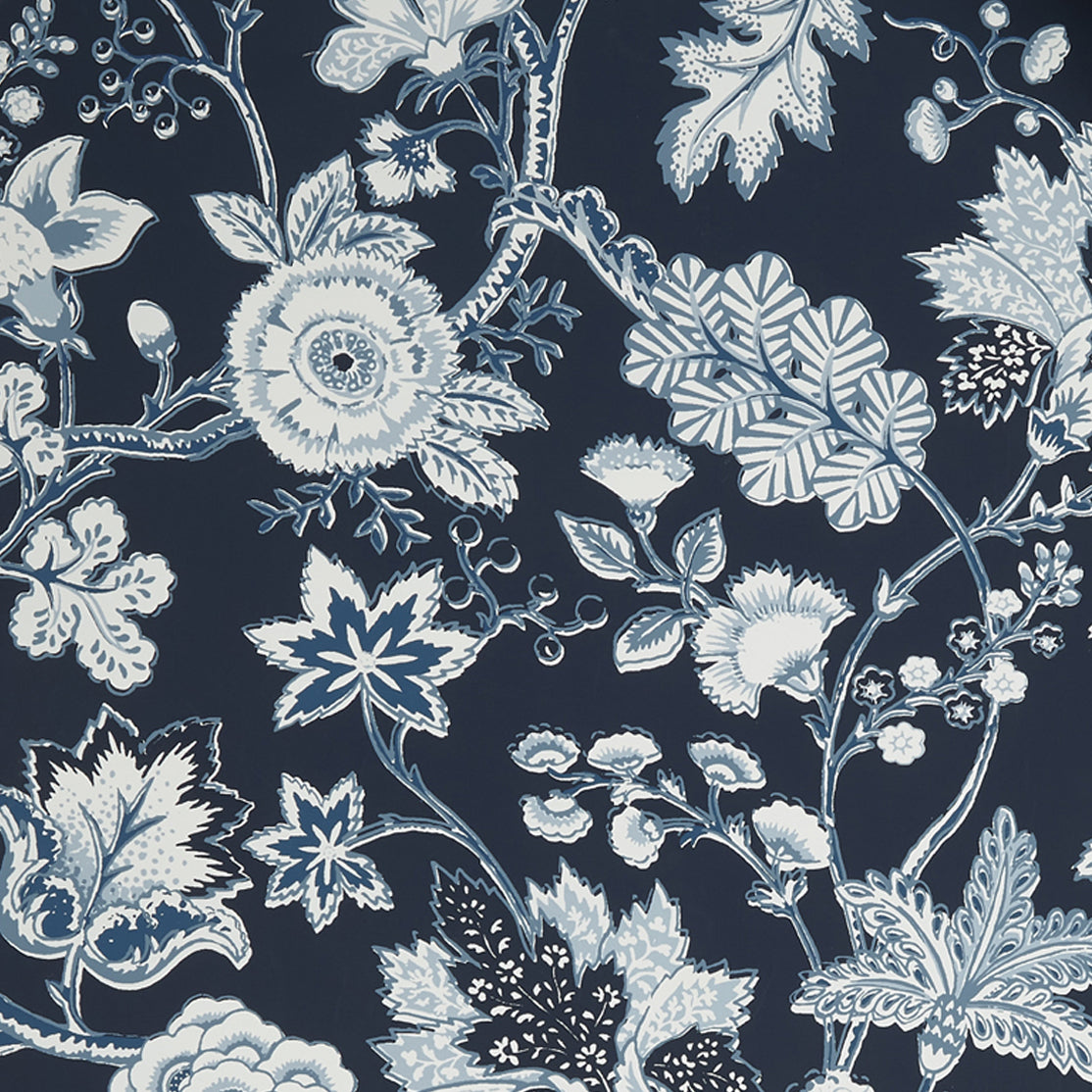 Close up of wallpaper in scrolling floral vine pattern in shades of blue and white on navy blue.
