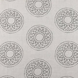 Detail of fabric in a repeating circular geometric print in gray on a greige field.