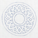 Detail of fabric in a repeating circular geometric print in blue on a white field.