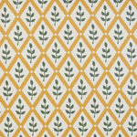Detail of fabric in a lattice and leaf print in green and yellow on a white field.