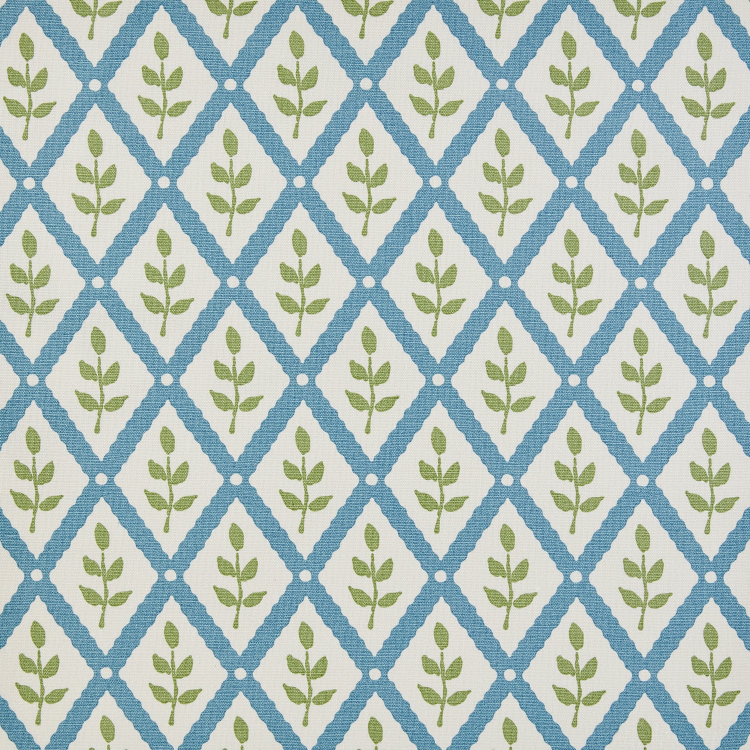 Detail of fabric in a lattice and leaf print in green and blue on a white field.
