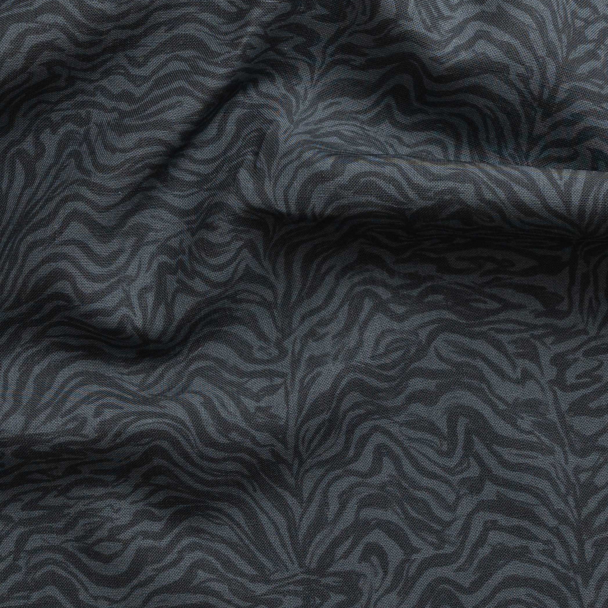 Detail of gently draped printed fabric with watercolor swirling stripe pattern in tonal navy blue.