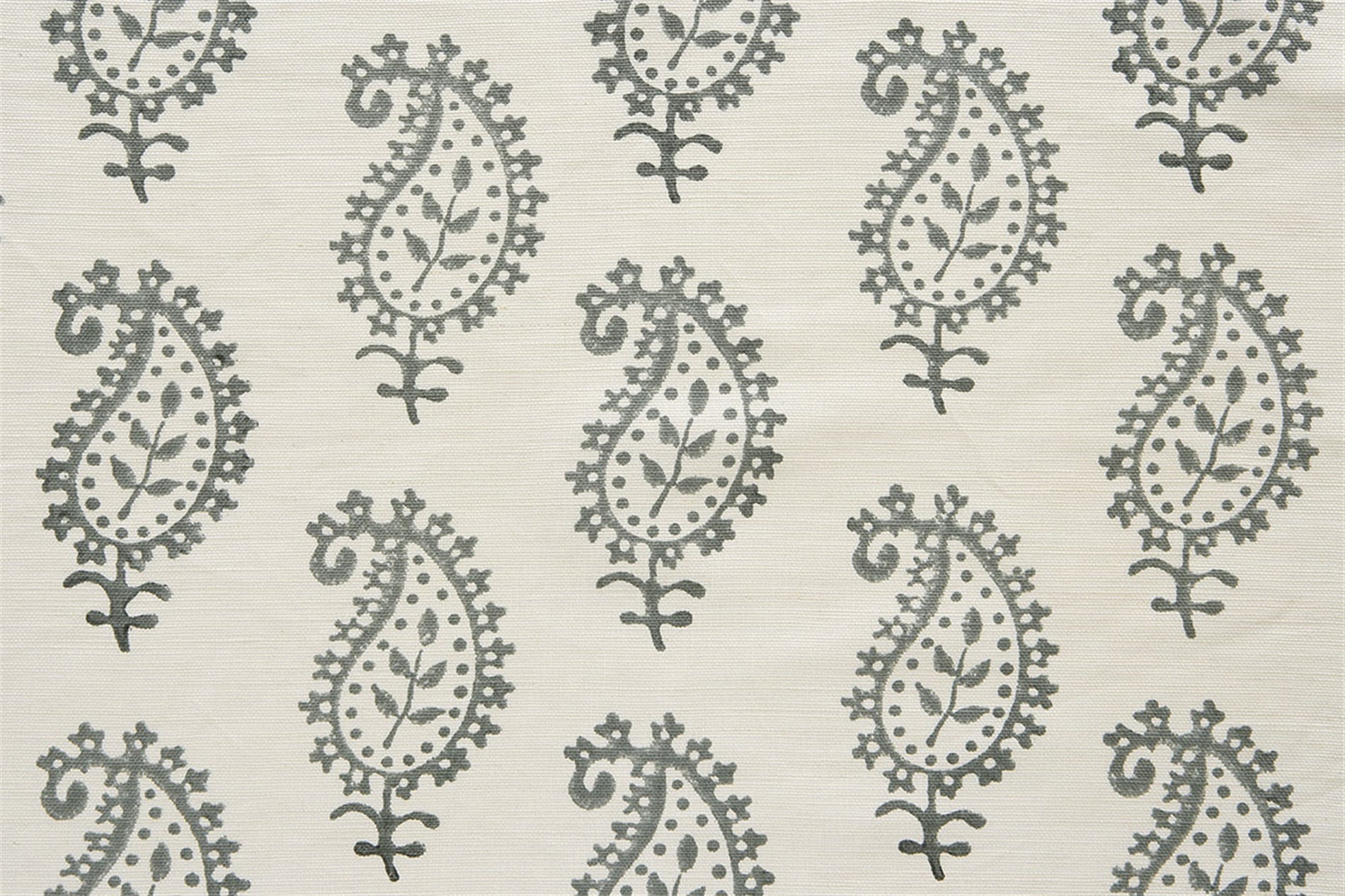 Detail of fabric in a repeating paisley print in gray on a cream field.