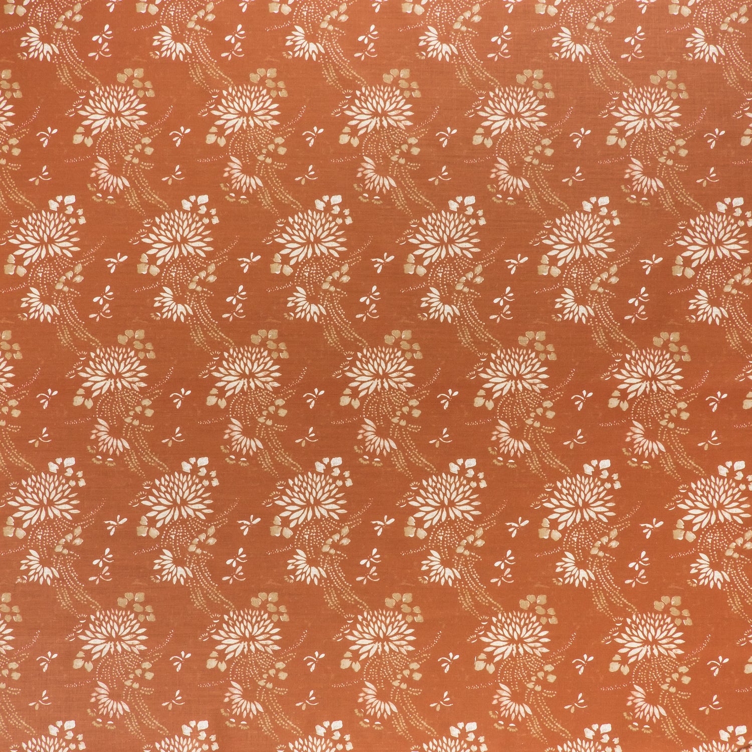 printed linen fabric in a floral and dot pattern in white and gold on a rust field.