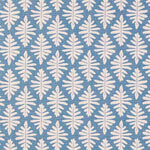 Detail of fabric in a repeating fern leaf print in white on a light blue field.