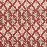 Detail of fabric in a repeating fern leaf print in cream on a dark red field.