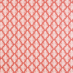 Detail of fabric in a repeating fern leaf print in white on a coral field.